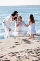 happy young family with daughter on beach in summer