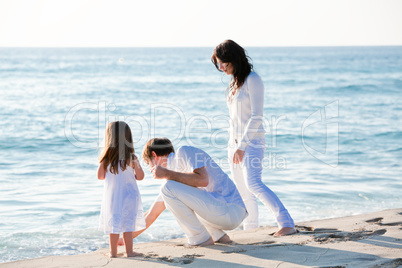 happy young family with daughter on beach in summer