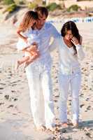 happy young family with daughter on beach in summer