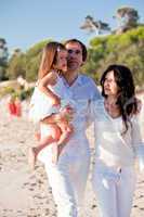 happy young family with daughter on beach in summer