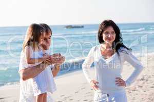 happy young family with daughter on beach in summer