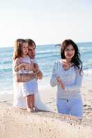 happy young family with daughter on beach in summer