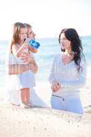 happy young family with daughter on beach in summer