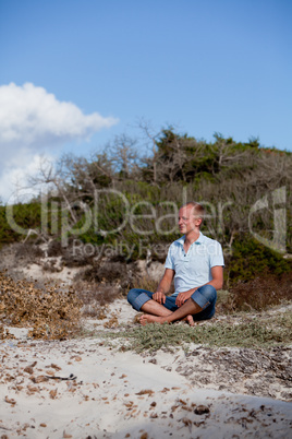 young man is relaxing outdoor in dune in summer