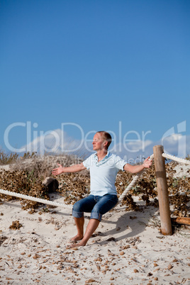 young man is relaxing outdoor in dune in summer