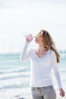 beautiful young woman drinking water in summer