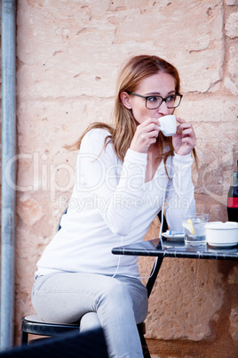 young woman is drinking coffee outdoor in summer