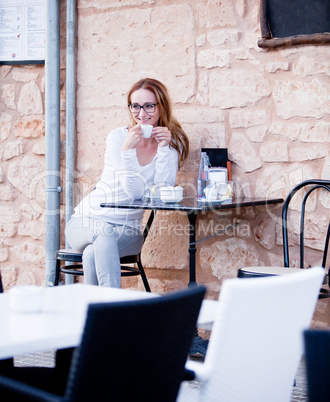 young woman is drinking coffee outdoor in summer