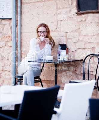 young woman is drinking coffee outdoor in summer