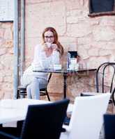 young woman is drinking coffee outdoor in summer