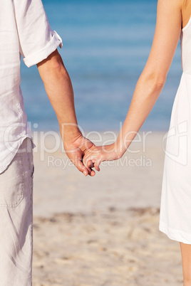 couple in love hand in hand on beach in summer