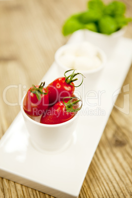 tasty tomatoes mazarella and basil on plate on table