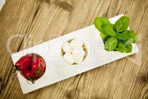 tasty tomatoes mazarella and basil on plate on table