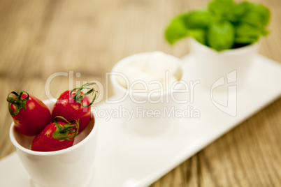 tasty tomatoes mazarella and basil on plate on table