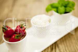 tasty tomatoes mazarella and basil on plate on table