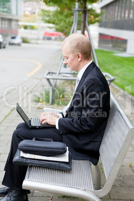 business man sitting outdoor working with notebook