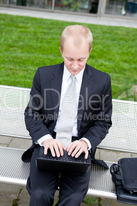 business man sitting outdoor working with notebook