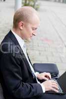 business man sitting outdoor working with notebook