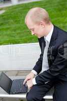 business man sitting outdoor working with notebook