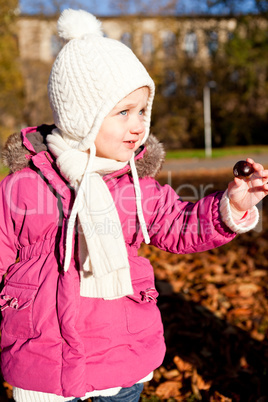 cute littloe girl playing outdoor in autumn