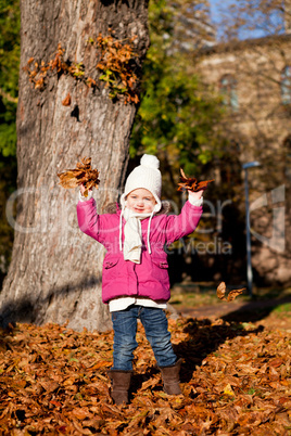 cute littloe girl playing outdoor in autumn