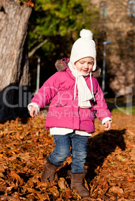 cute littloe girl playing outdoor in autumn