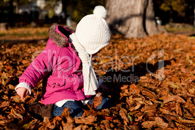 cute littloe girl playing outdoor in autumn