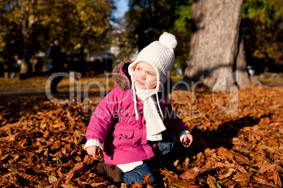 cute littloe girl playing outdoor in autumn