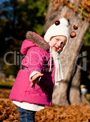 cute littloe girl playing outdoor in autumn