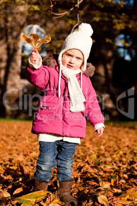 cute littloe girl playing outdoor in autumn