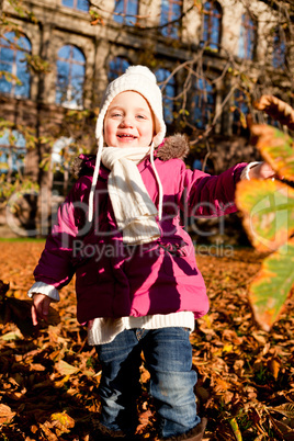 cute littloe girl playing outdoor in autumn