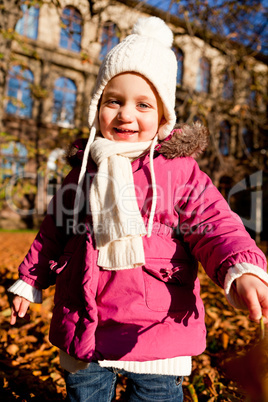 cute littloe girl playing outdoor in autumn