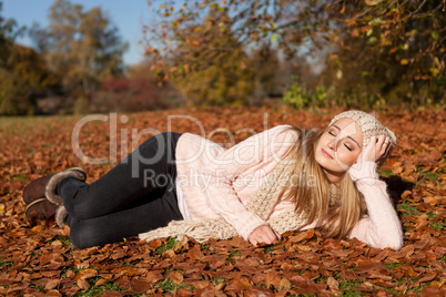 young smiling woman with hat and scarf outdoor in autumn