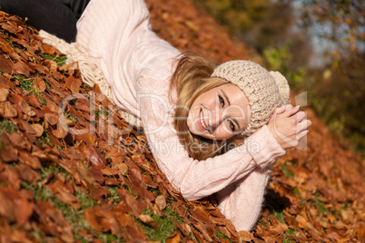 young smiling woman with hat and scarf outdoor in autumn