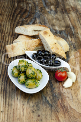 green olives with fresh bread and herbs