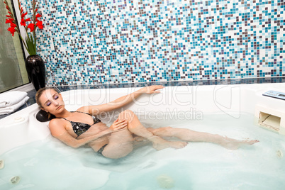 attractive blonde woman relaxing in jacuzzi whirlpool spa