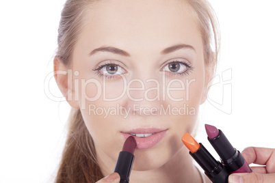 young beautiful woman applying colored lipstick