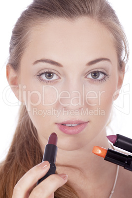 young beautiful woman applying colored lipstick