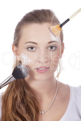 young beautiful woman applying mineral powder