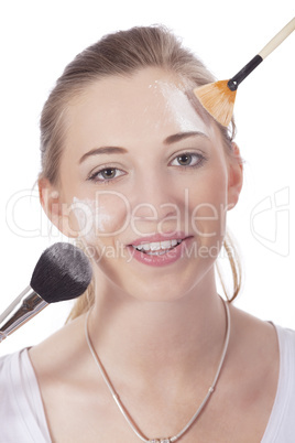 young beautiful woman applying mineral powder