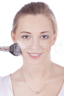 young beautiful woman applying mineral powder