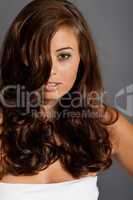 young woman portrait with shiny healthy brown curly hair