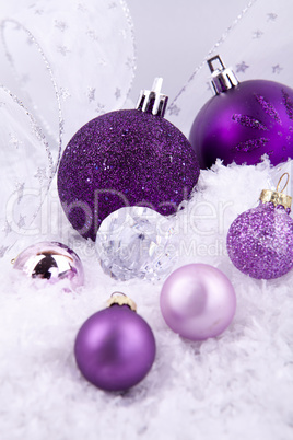 beautiful christmas decoration in purple and silver on white snow