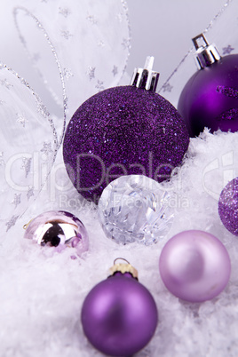 beautiful christmas decoration in purple and silver on white snow