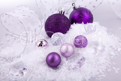 beautiful christmas decoration in purple and silver on white snow