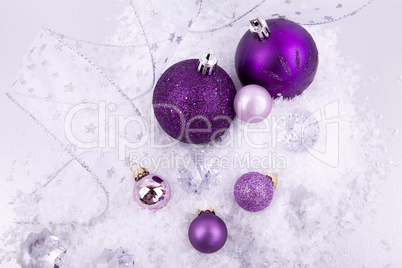 beautiful christmas decoration in purple and silver on white snow