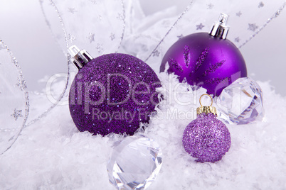 beautiful christmas decoration in purple and silver on white snow