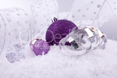 beautiful christmas decoration in purple and silver on white snow