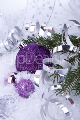 beautiful christmas decoration in purple and silver on white snow