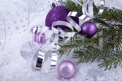 beautiful christmas decoration in purple and silver on white snow